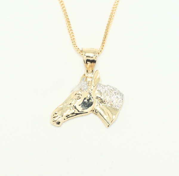 Yellow gold high relief horse head pendant whit white gold main on a yellow gold franco chain.