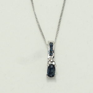 white gold sapphire in line pendant on fine chain.