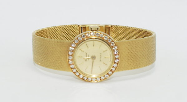 Ladies petitte yellow gold watch with round diamond bezel.